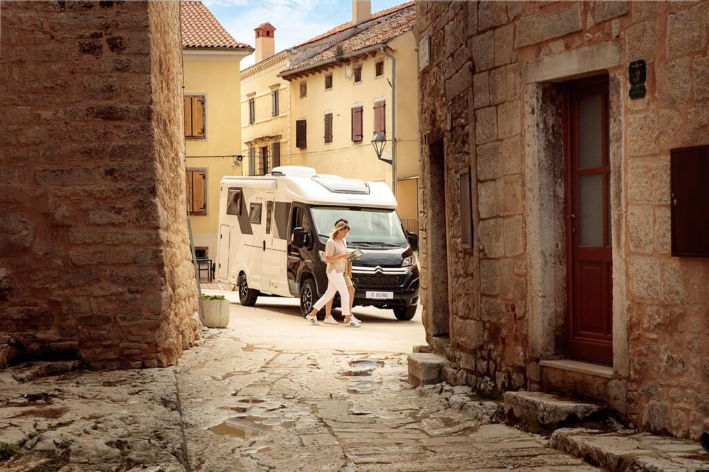 Sunliving C Serie Camper steht auf einem Platz in einer alten Italienischen Stadt.